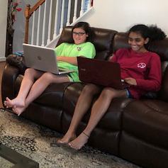 Two tech teens working on their laptops