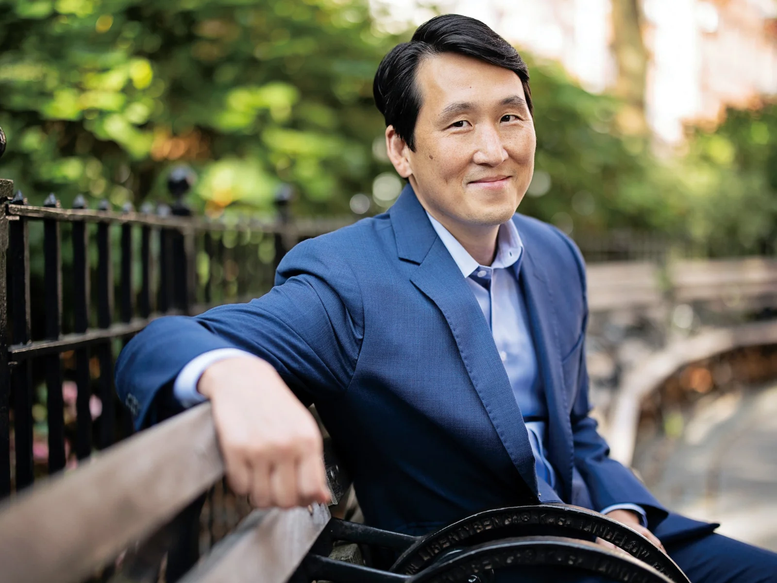 A portrait of James Rhee sitting on a bench